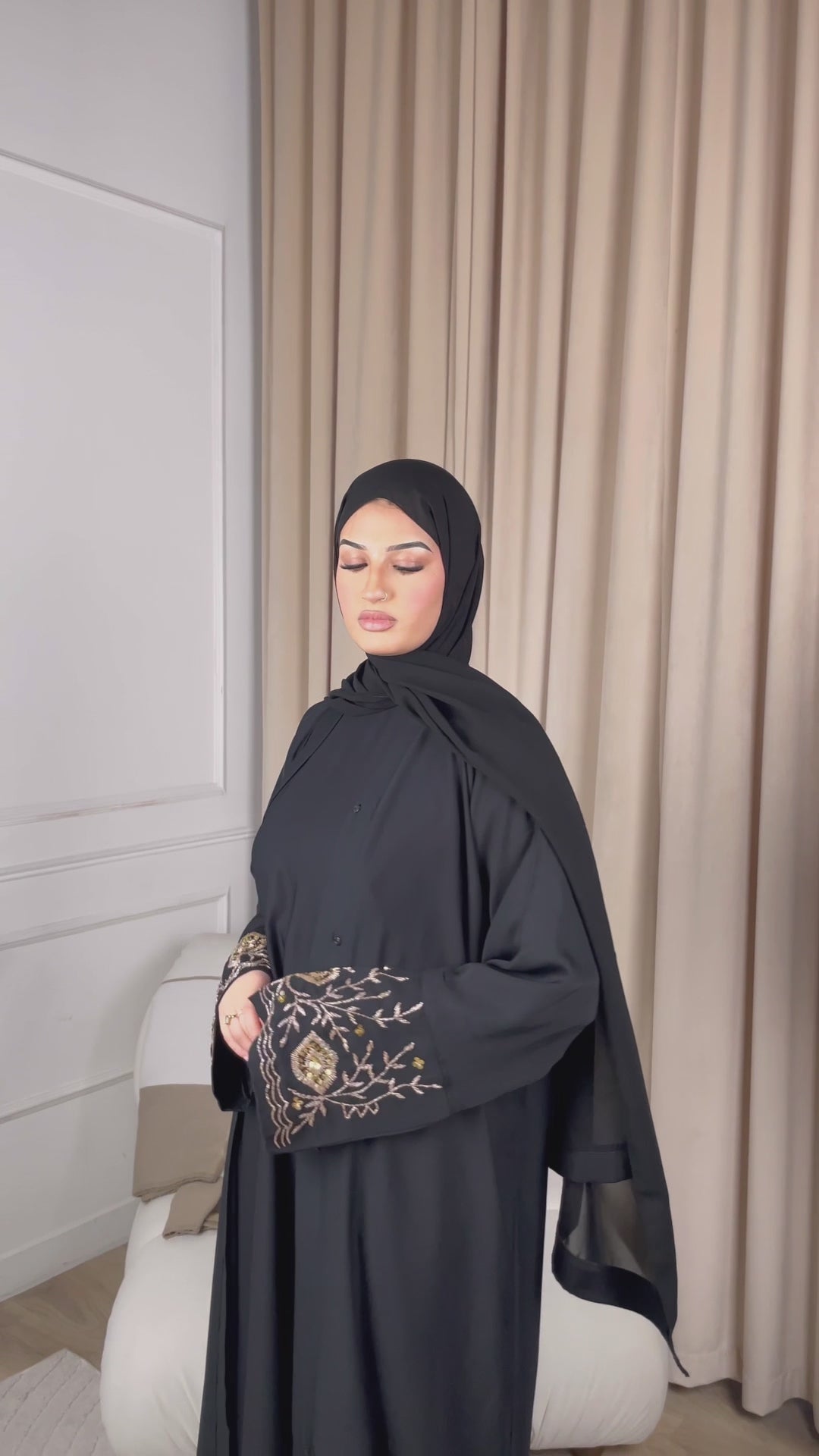 Load video: A graceful model confidently showcases a flowing black abaya, designed with modern modesty in the mind. The abaya features delicate embroidery along the sleeves, adding an elegant touch. The model walks gracefully, highlighting the abayas lightweight fabric and versatile design. The setting is a minimalist backdrop with soft lighting, emphasising the sophistication and simplicity of the outfit. Perfect for women seeking a blend of traditional and contemporary style.